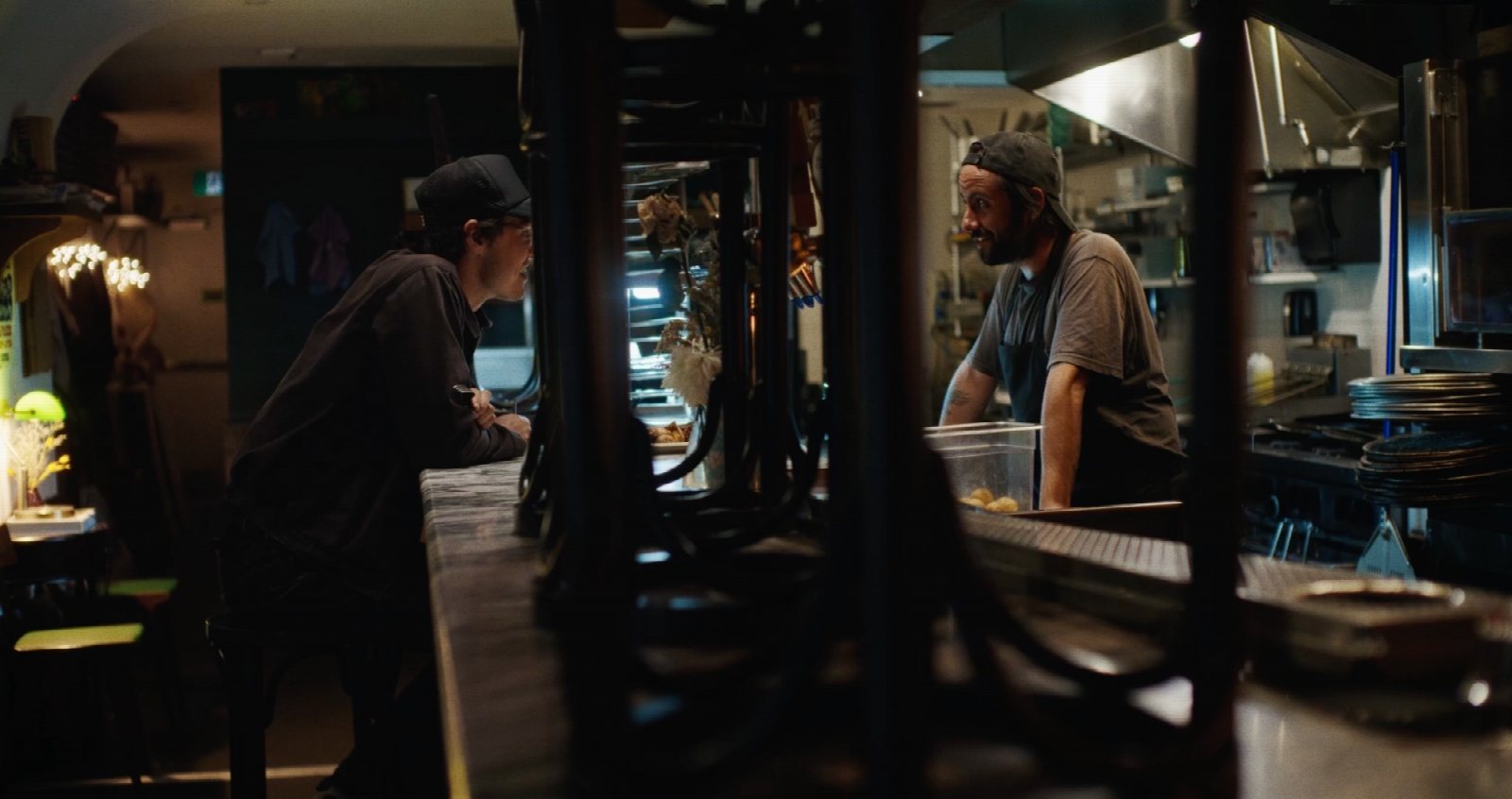 Anna Hopkins on the Dish Pit set with Matthew Gouveia and Austin Hutchings in a warm restaurant interior